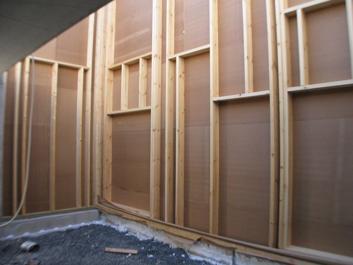 Houten stijlen met houtvezelplaten in een wand in opbouw